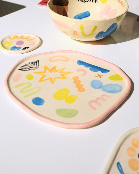 Colorful ceramic plates with abstract designs on a white surface